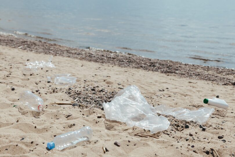 Plastprodukter som ligger utspridda på en sandstrand.