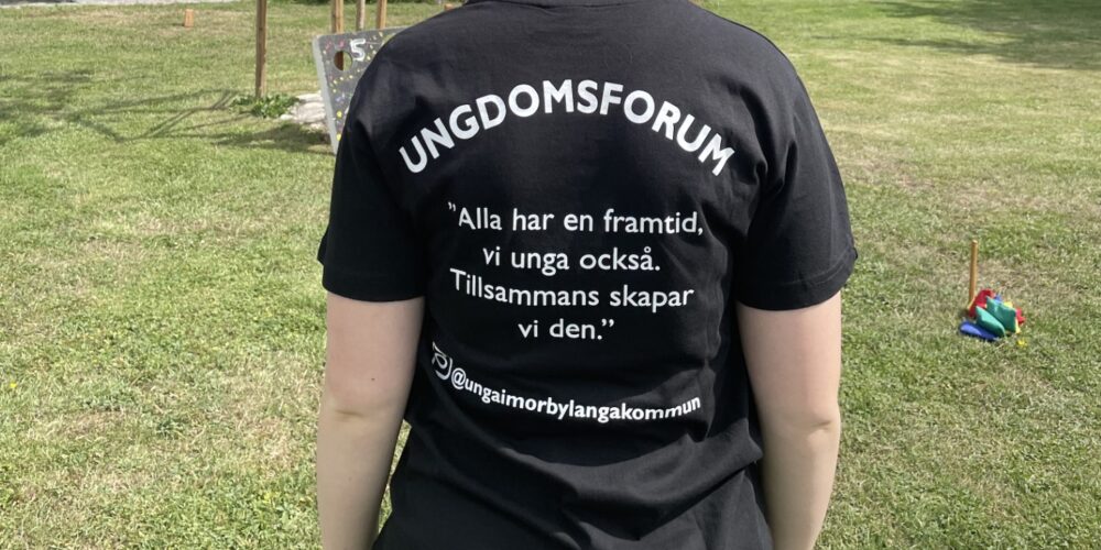 Visar en persons rygg. Svart tröja med vit text, ungdomsforum