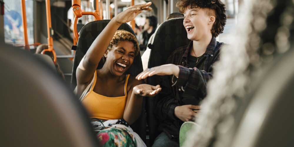 Två glada ungdomar på en buss. Foto: Mostphotos