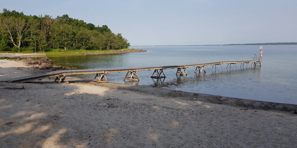 Sandstrand och badbrygga vid Borgmästarvikens badplats