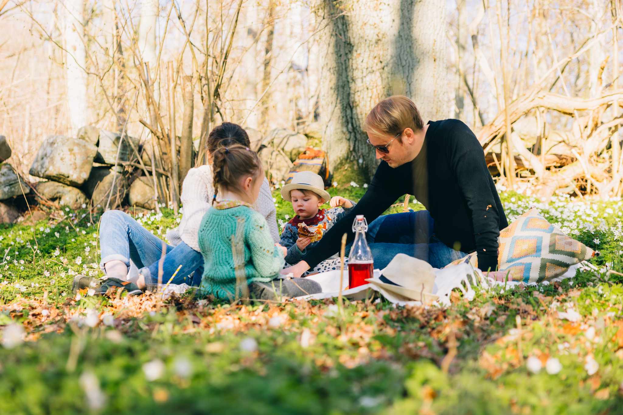 Familj har picknick bland vitsippor