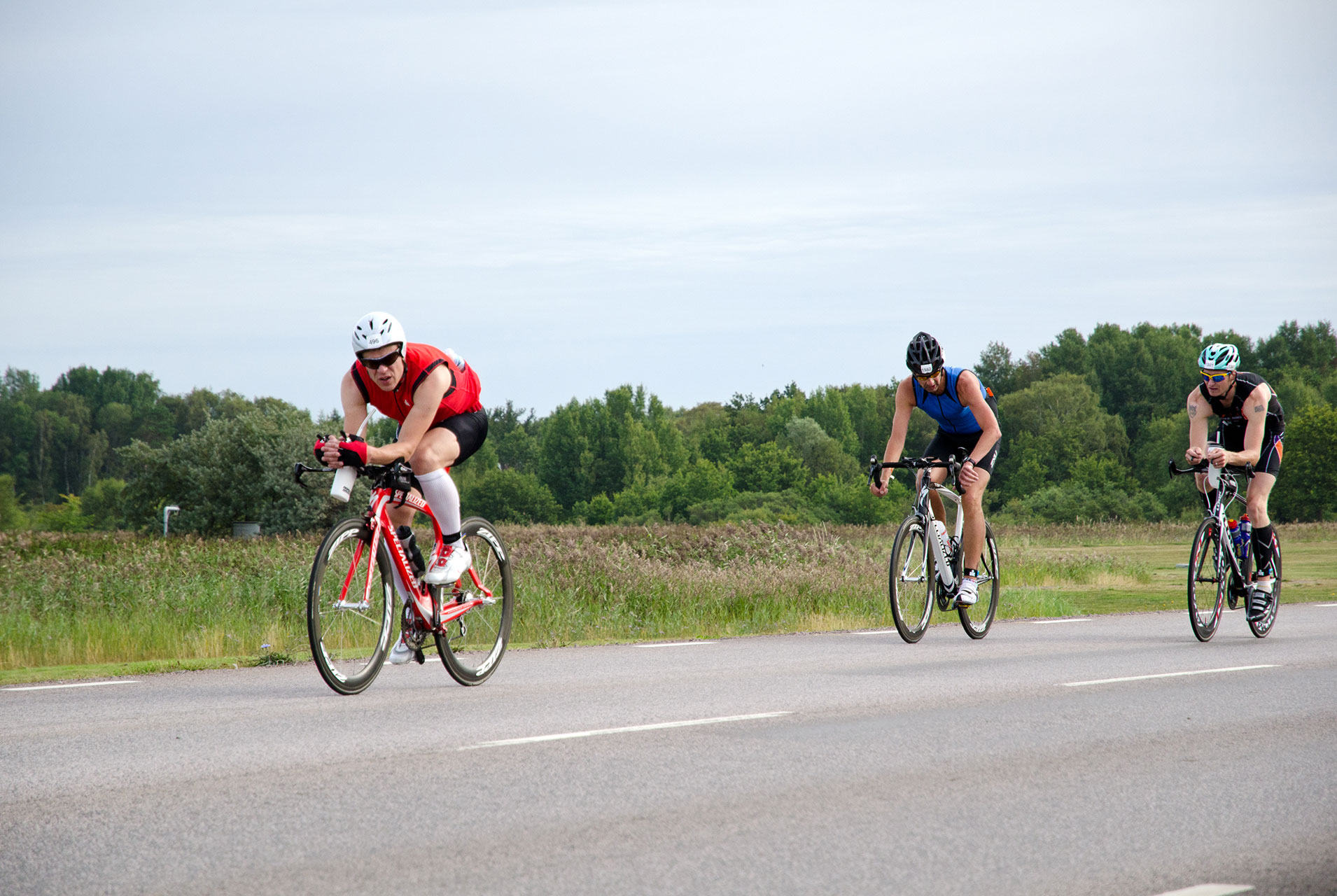 Tre cyklister från Ironman cyklar längs ölandsväg.