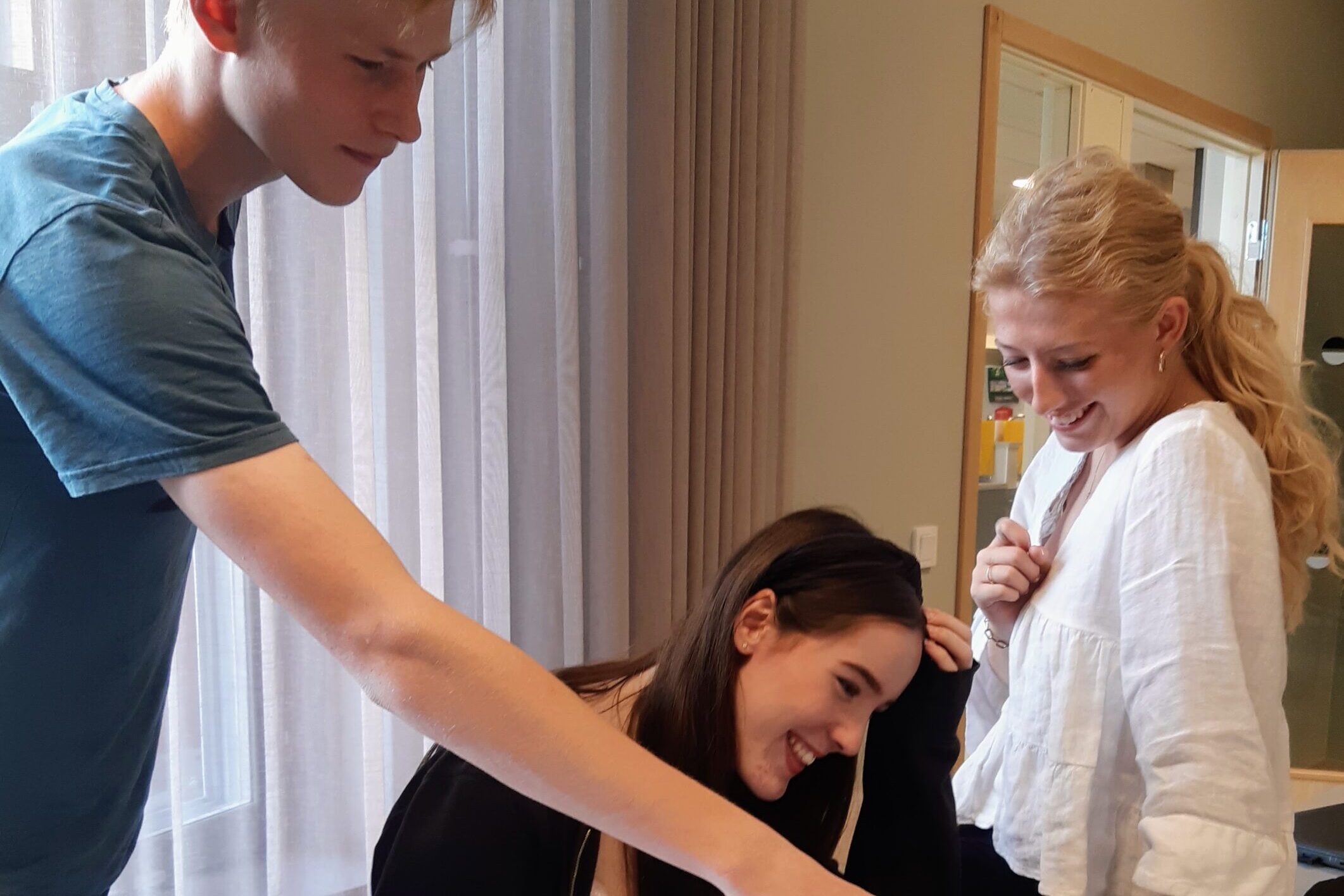 Tre ungdomar tittar på en datorskärm tillsammans.