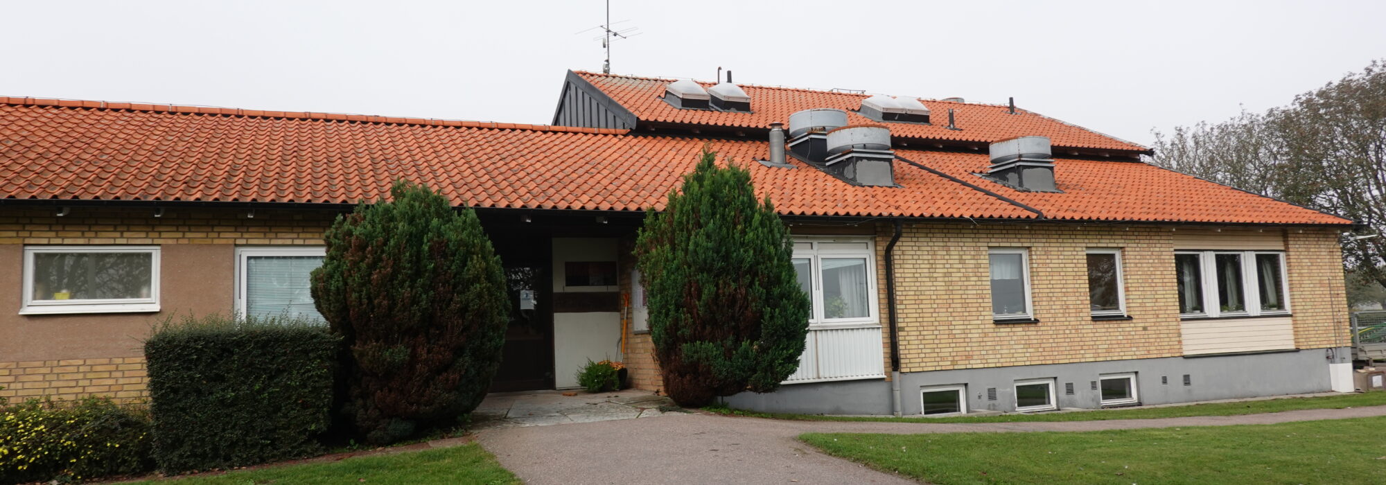 Huset och entrén till syrenen, alungården, en asfalterad gång upp till dörren