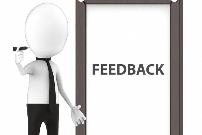 tecknad figur utan ansikte med slips som skriver feedback på en plansch