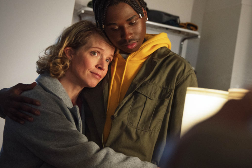 En medelålders kvinna kramar en tonårskille.