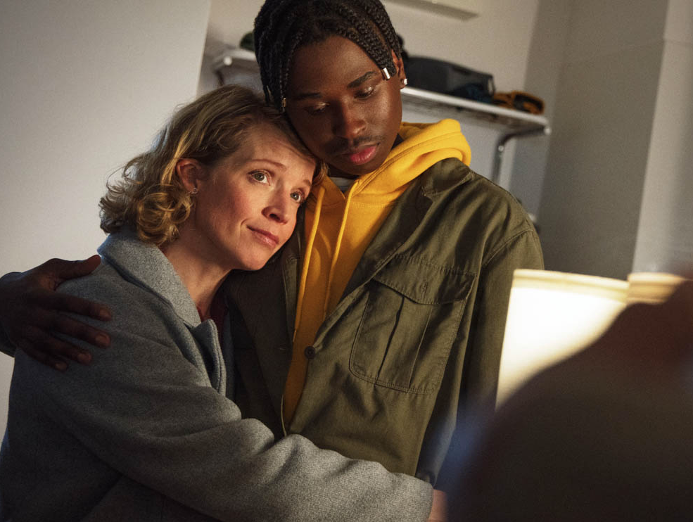 En medelålders kvinna kramar en tonårskille.