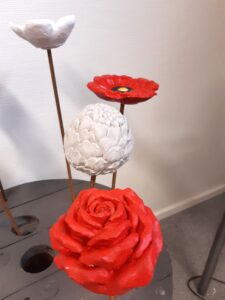 Målade betongblommor på armeringspinnar
