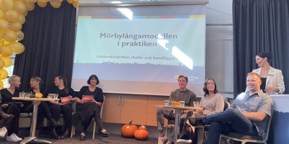 Chefer, undersköterskor och biståndshandläggare i en öppen panel på scenen.