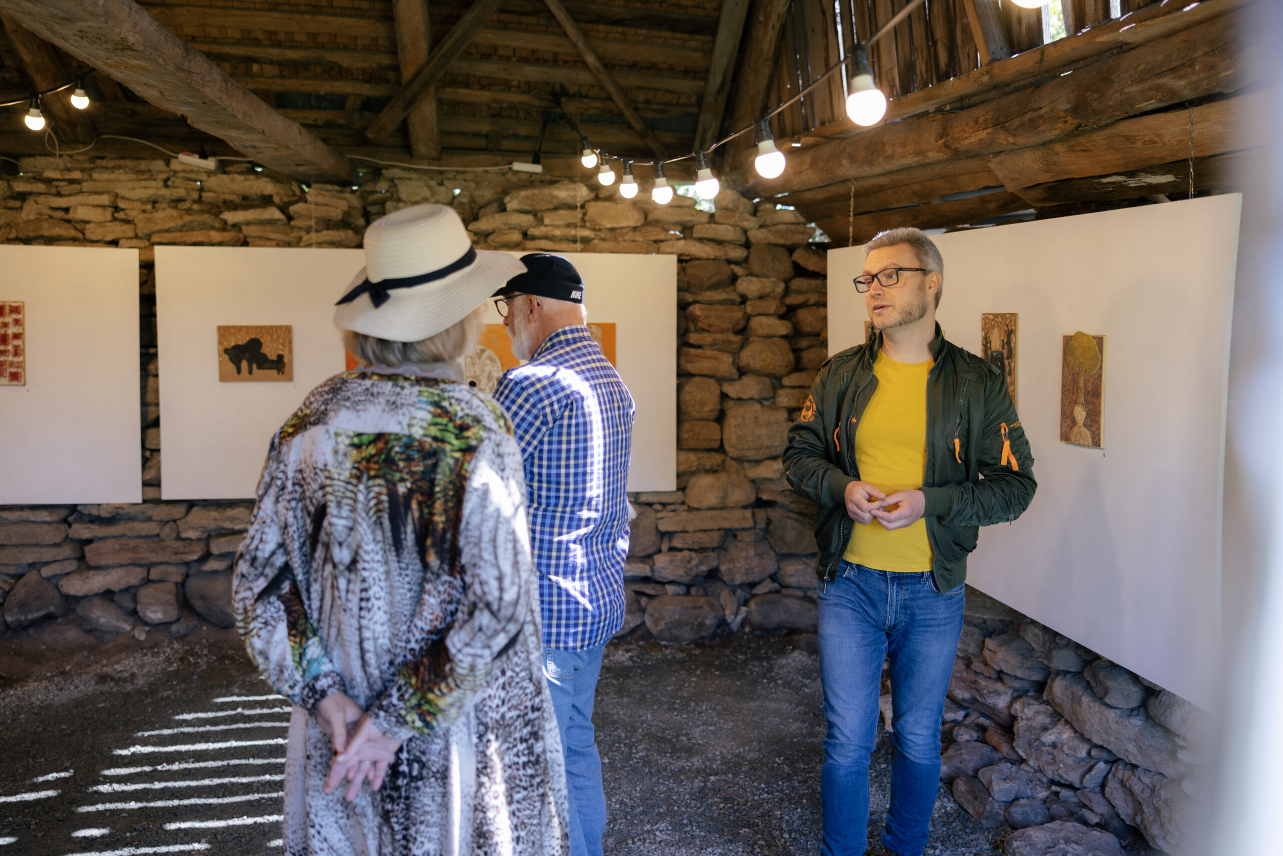 Tre personer på en konstutställning i en stenlada. Foto; Alexander Hall, oland.se