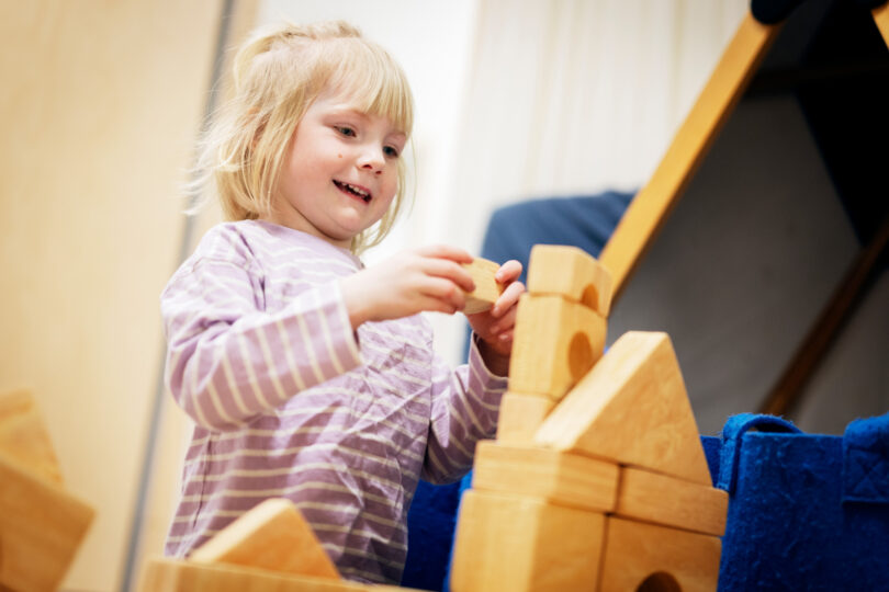 En barn i förskolan bygger med klossar.