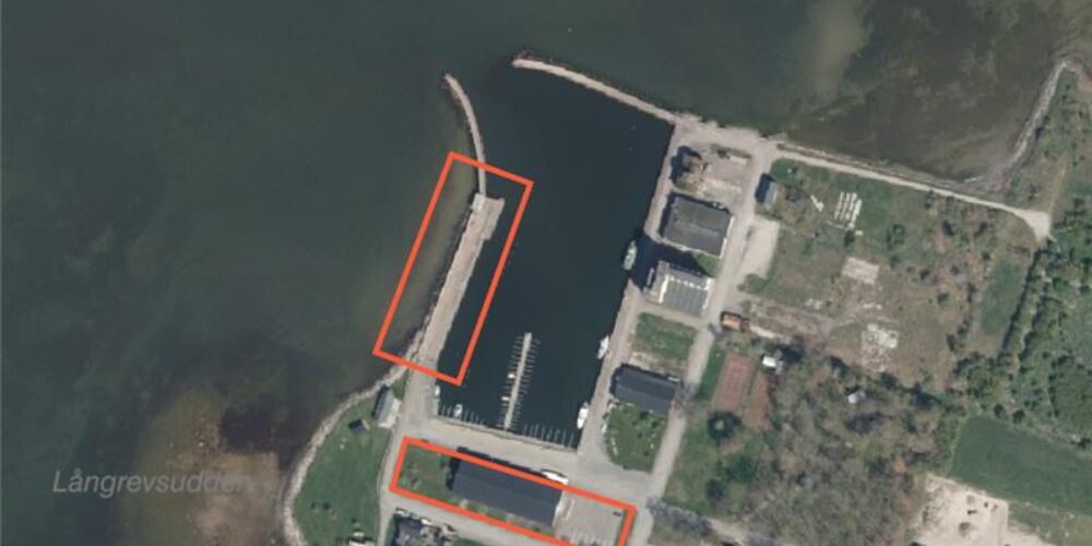 Satellitvy över en kusthamn med pir och bryggor; två områden är markerade med röda rektanglar runt en lång pir samt en byggnadslänga vid hamnplanen, intill vatten och bebyggelse. Text: ”Långrevstudden”.
