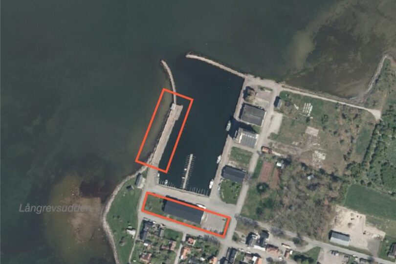 Satellitvy över en kusthamn med pir och bryggor; två områden är markerade med röda rektanglar runt en lång pir samt en byggnadslänga vid hamnplanen, intill vatten och bebyggelse. Text: ”Långrevstudden”.